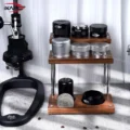 Regal voller schwarzer und silberner Distributoren und Werkzeuge neben einer manuellen Hebel-Espressomaschine auf Marmor