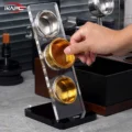 Hand setzt ein goldenes Sieb in die mittlere Aufnahme des IKAPE Acryl-Ständers mit drei Aufnahmen