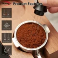 Hand rührt mit den Nadeln des schwarzen Werkzeugs Kaffeemehl in einem Siebträger auf einem Holzhalter