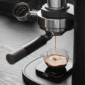 Espresso läuft aus der Brühgruppe der Alkaid in ein kleines Glaskännchen auf einer Digitalwaage