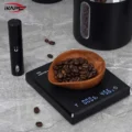 Holzschale mit Kaffeebohnen auf einer schwarzen Digitalwaage, daneben eine schwarze Sprühflasche