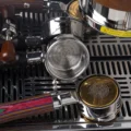 Draufsicht auf drei Siebträger auf einer Abtropfschale, im vorderen ein goldenes Clockwork-Sieb