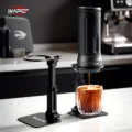 Zwei Ständer auf einer weißen Arbeitsfläche, einer leer, der andere hält eine tragbare Maschine über Eiskaffee