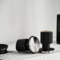 Zwei Geometry Impact-Tamper auf einem weißen Regal, einer liegend mit gerillter Fläche, einer aufrecht