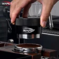 Hand setzt den schwarzen Distributor auf einen Siebträger mit Kaffeemehl unter einer Espressomaschine