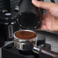 Der V2 Becher vom Siebträger abgehoben, kleine Magnete rund um den Rand seines Bodens sichtbar