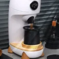 Der V2 Becher unter dem Auswurf einer weißen Mühle fängt fallendes Kaffeemehl auf