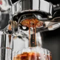 Nahaufnahme: Espresso läuft in mehreren Strahlen aus der Unterseite des KKLUO Präzisionssiebs