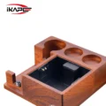 Rötlicher Abklopfbehälter aus Holz mit schwarzem Einsatz, innen ein quadratisches schwarzes Pad auf dem Klopfpfosten