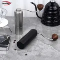 Silberne Line Mühle aufrecht, schwarze liegend auf Marmor, dahinter ein Handfilter und ein gesprenkelter Kessel