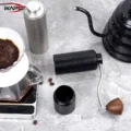 Schwarze Line Mühle liegend ohne Auffangkammer, dahinter die silberne Mühle und ein Pour-over
