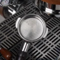 Leeres silbernes Matrix-Sieb in einem Siebträger von oben, feine Löcher über den ganzen Boden