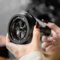 Hand hält das WDT-Tool seitlich und zeigt die feinen Nadeln unter dem runden schwarzen Kopf