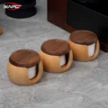 Three lidded filter boxes in a row on a grey marble floor, their notches facing the camera