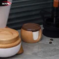 One lidded filter box on a grey counter between a white and wood container and a black grinder