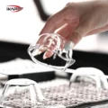 Hand hebt ein umgedrehtes Petal Glas von einer Abtropfmatte, daneben zwei weitere umgedrehte Gläser