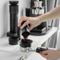 Kaffeemehl wird aus einem Dosierbecher durch einen Trichter in den Polaris Siebträger auf einer weißen Matte gegossen