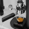 Polaris Siebträger unter einer manuellen Espressomaschine mit Manometer, Espresso läuft in ein Glas auf einer Waage