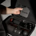 Hand hebt eine flache Platte mit IKAPE Logo aus dem Netzfach über dem gepackten unteren Fach