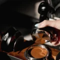 UniPress vom Siebträger abgehoben: die Stahlfläche mit Flügeln und ein zu Ringen gepresstes Kaffeebett