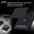Schwarze Waage mit darüber abgehobener Silikonmatte, dahinter ein Pour-over-Dripper auf einer zweiten Waage