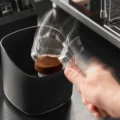 Siebträger schlägt auf den Block des V2 Behälters, der ausgebrauchte Puck löst sich, mit Bewegungsunschärfe