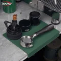 Dunkelgrüne IKAPE Matte über die Kante der Arbeitsplatte geklappt, mit Siebträger, WDT-Tool, Distributor und Tamper