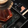 Handy neben der schwarzen IKAPE V2 Pro Waage zeigt einen Live-Aufguss mit 172,3 g bei 01:31 und Verhältnis 1:11,3