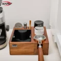 IKAPE V2 Nussbaum-Organizer neben einer Mühle, ein Siebträger mit Holzgriff im vorderen Schlitz