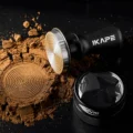 Schwarzer V3 liegend neben einem zu Ringen gepressten Kaffeehügel, daneben ein Distributor