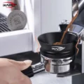 Kaffeemehl fällt aus dem Auswurf einer Mühle in den schwarzen Trichter auf einem Siebträger, eingeblendet ein Puck Screen