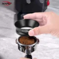 Hand hebt den schwarzen Trichter von einem Siebträger, die Dosis Kaffeemehl bleibt im Sieb