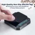 Hand hebt eine gerippte schwarze Silikonmatte von der Glasoberseite der V3 Waage