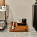 Nussbaumstation auf Marmor zwischen Espressomaschine und Mühle, ein Siebträger in der Ablage