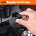 Hand hält ein WDT-Tool mit Nadeln, ein schwarzes Puck Screen an seine Unterseite gedrückt, über einer schwarzen Station