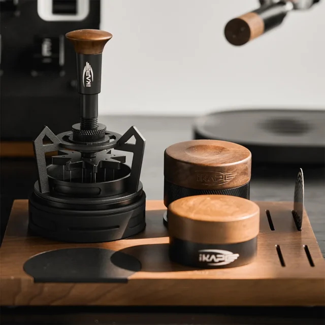 V4 auf einem Holztablett neben einem kürzeren Werkzeug mit Nussbaumkopf und einem WDT-Tool im schwarzen Spinnenbein-Ständer