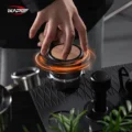 Hand dreht den V5 auf einem Siebträger, orange Ringe markieren die Drehung