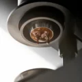 Espresso sammelt sich am Boden mit 32 mm des Siebs, zwei Tropfen fallen, von unter dem Brühgerät gesehen