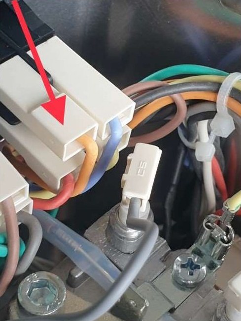 Nahaufnahme der Buchse am runden Netzschalter, mit einem roten Pfeil markiert