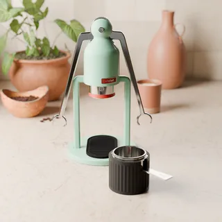 Schwarzer Siebträgerständer mit dem Robot-Siebträger neben einem Cafelat Robot in einer Küche