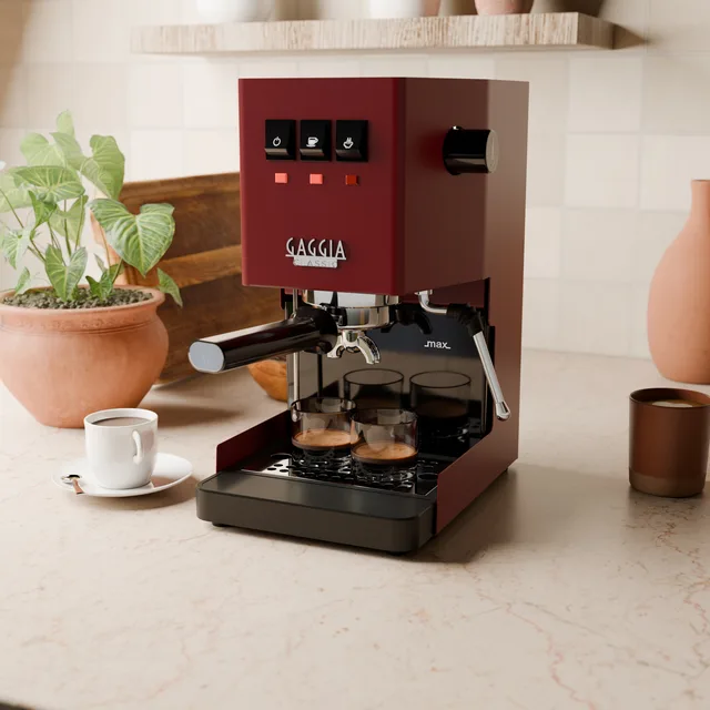 Schwarze verlängerte Abtropfschale mit zwei Espressogläsern auf dem Gitter einer roten Gaggia Classic in der Küche