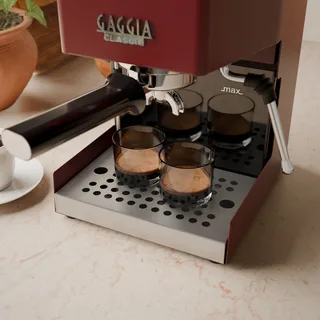 Nahaufnahme zweier Espressogläser auf dem Edelstahlgitter unter der Brühgruppe in der Küche
