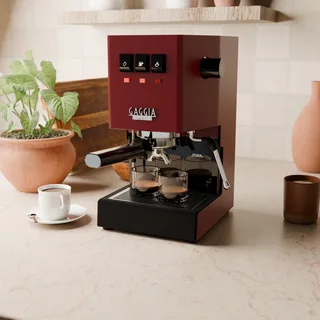 Geschlitztes Edelstahlgitter unter zwei Espressogläsern auf einer roten Gaggia Classic in der Küche