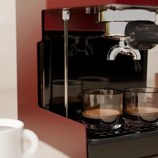 Nahaufnahme des langen Entlüftungsrohrs neben zwei Espressogläsern in der Küche