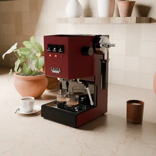 Schwarzer magnetischer Halter mit Siebträger an der Seite einer roten Gaggia Classic in der Küche
