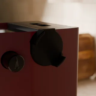 Nahe Ansicht des leeren magnetischen Halters an der Seite einer roten Gaggia Classic in der Küche