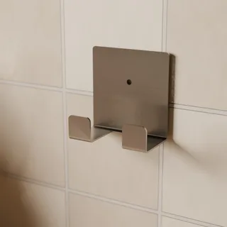 Leerer einzelner Wandhalter an einem gekachelten Fliesenspiegel im Winkel in der Küche