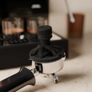 VDT Tool auf einem Siebträger mit Auslauf auf einer Steinplatte, Espressomaschine dahinter