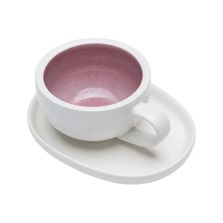 Rosa Latte-Tasse und ovale Untertasse auf Weiß, innen gesprenkelte rosa Glasur, gebogener Henkel rechts
