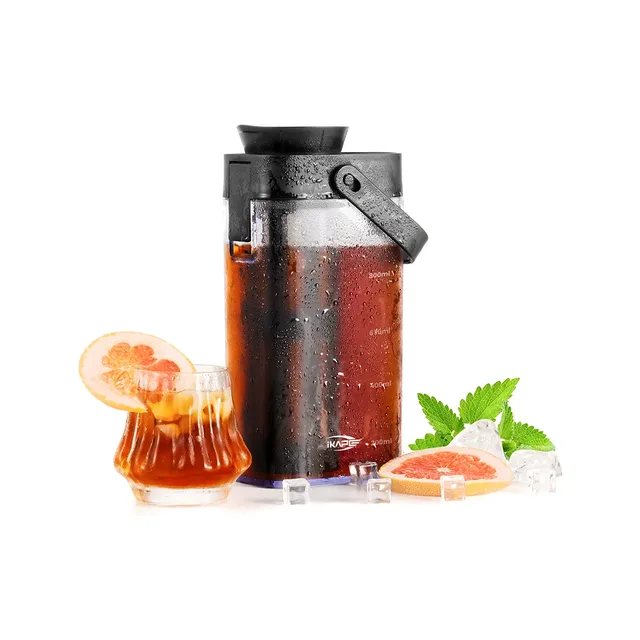 IKAPE Cold Brew Kanne Glas mit schwarzem Deckel und Griff, voll Cold Brew, daneben ein Eisgetränk mit Grapefruit